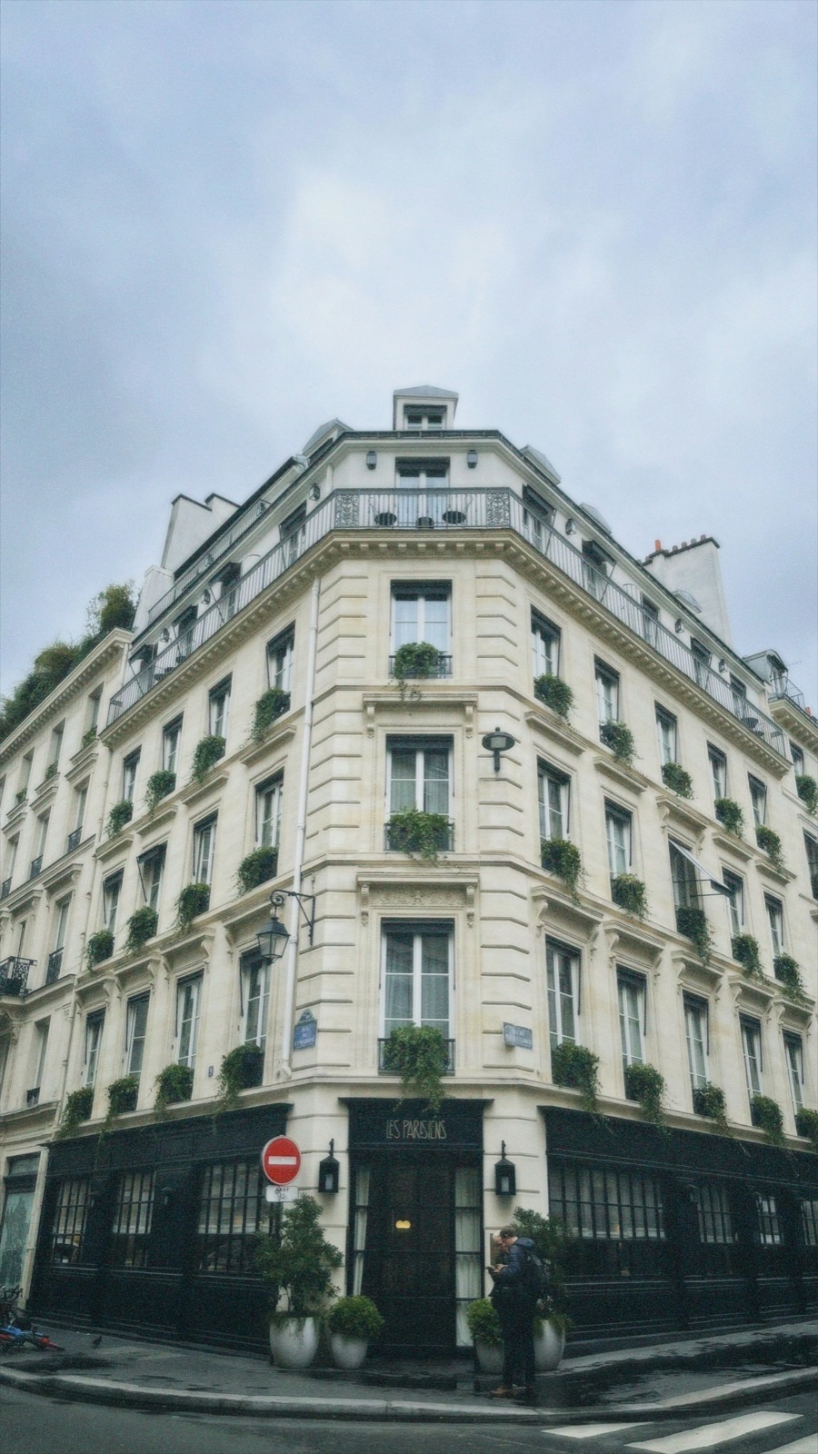Immeuble d’angle haussmannien aux balcons garnis de jardinières